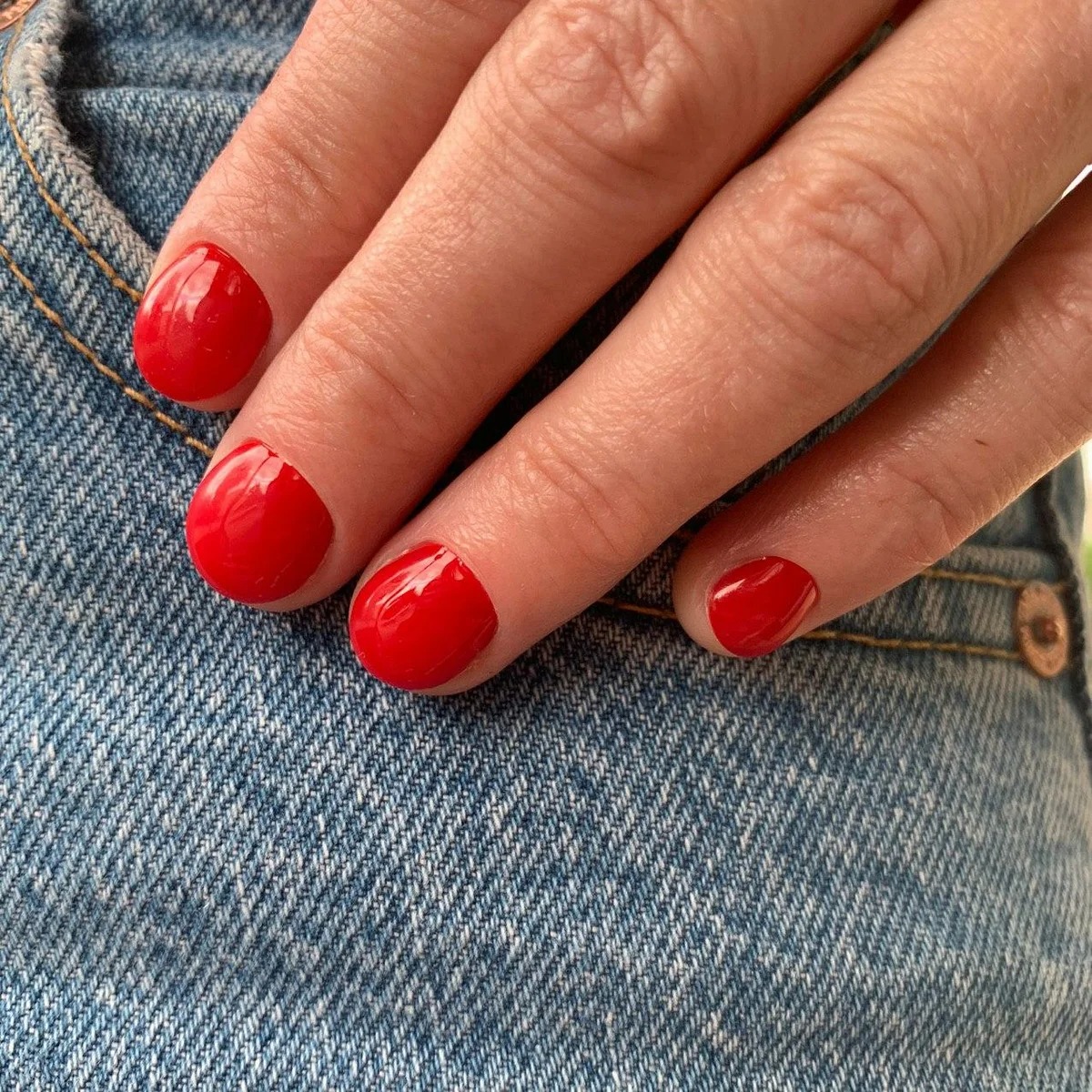Красный лак на коротких ногтях
