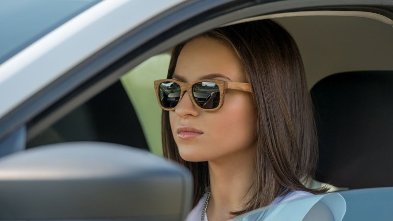 Рыжая девушка в очках солнечных на машине