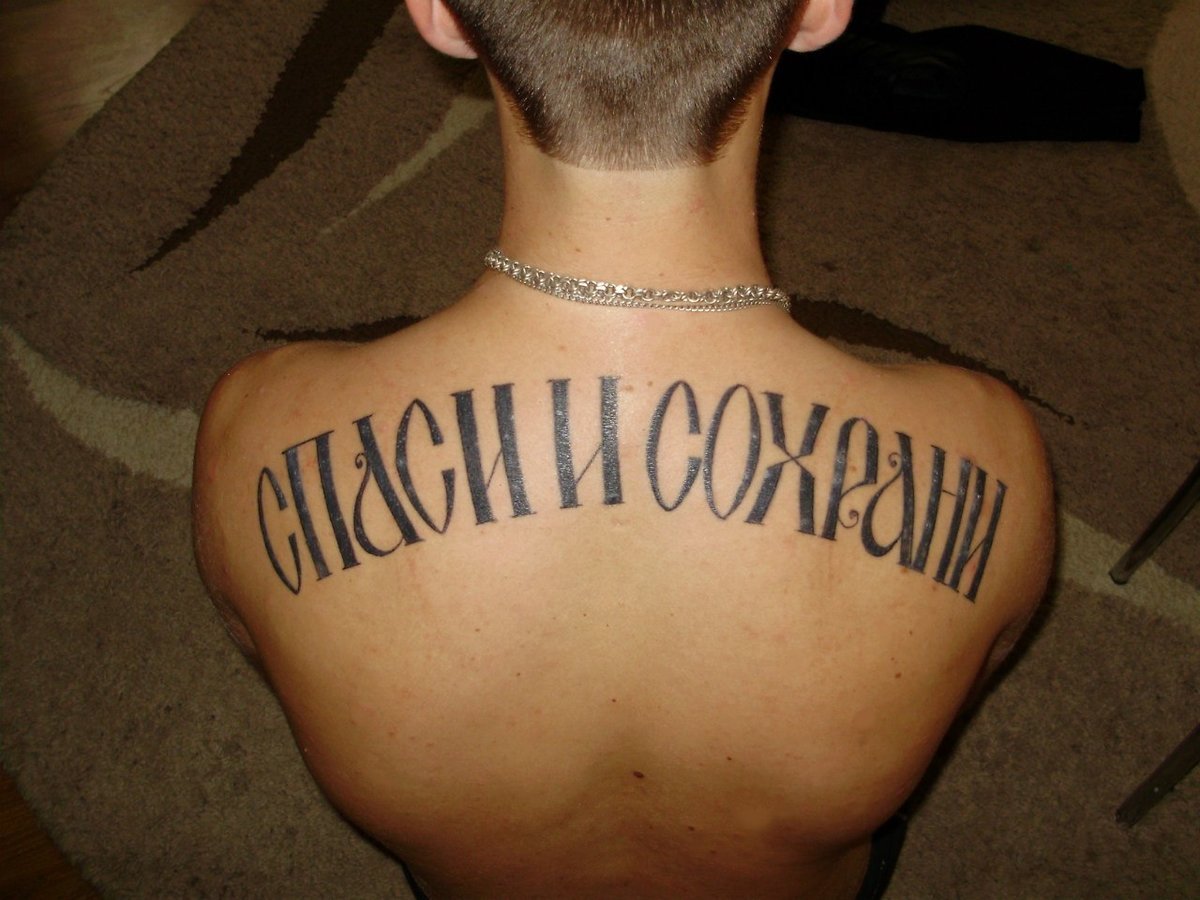 Татуировка надпись на спине Спаси и сохрани