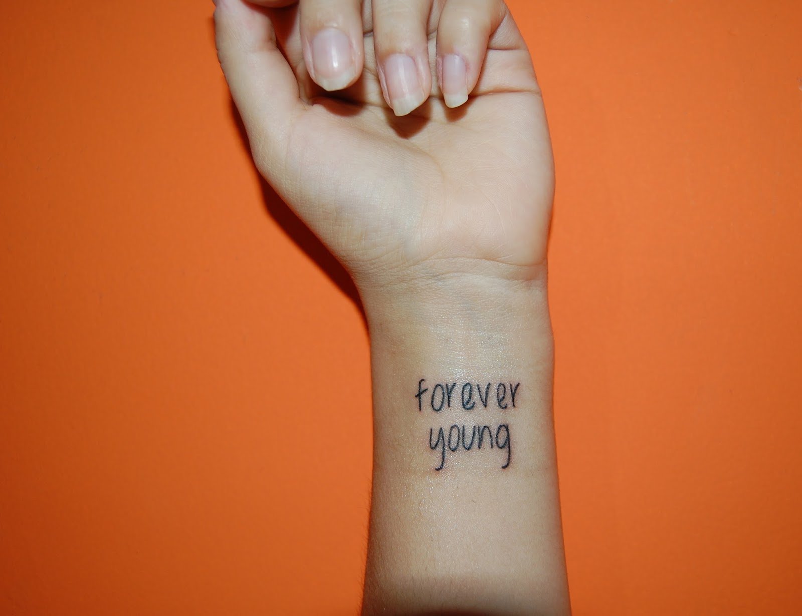 Тату Forever young на руке
