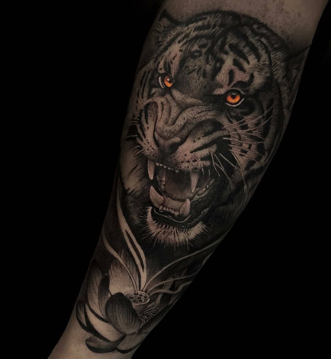 Тигр с оскалом тату на руке.