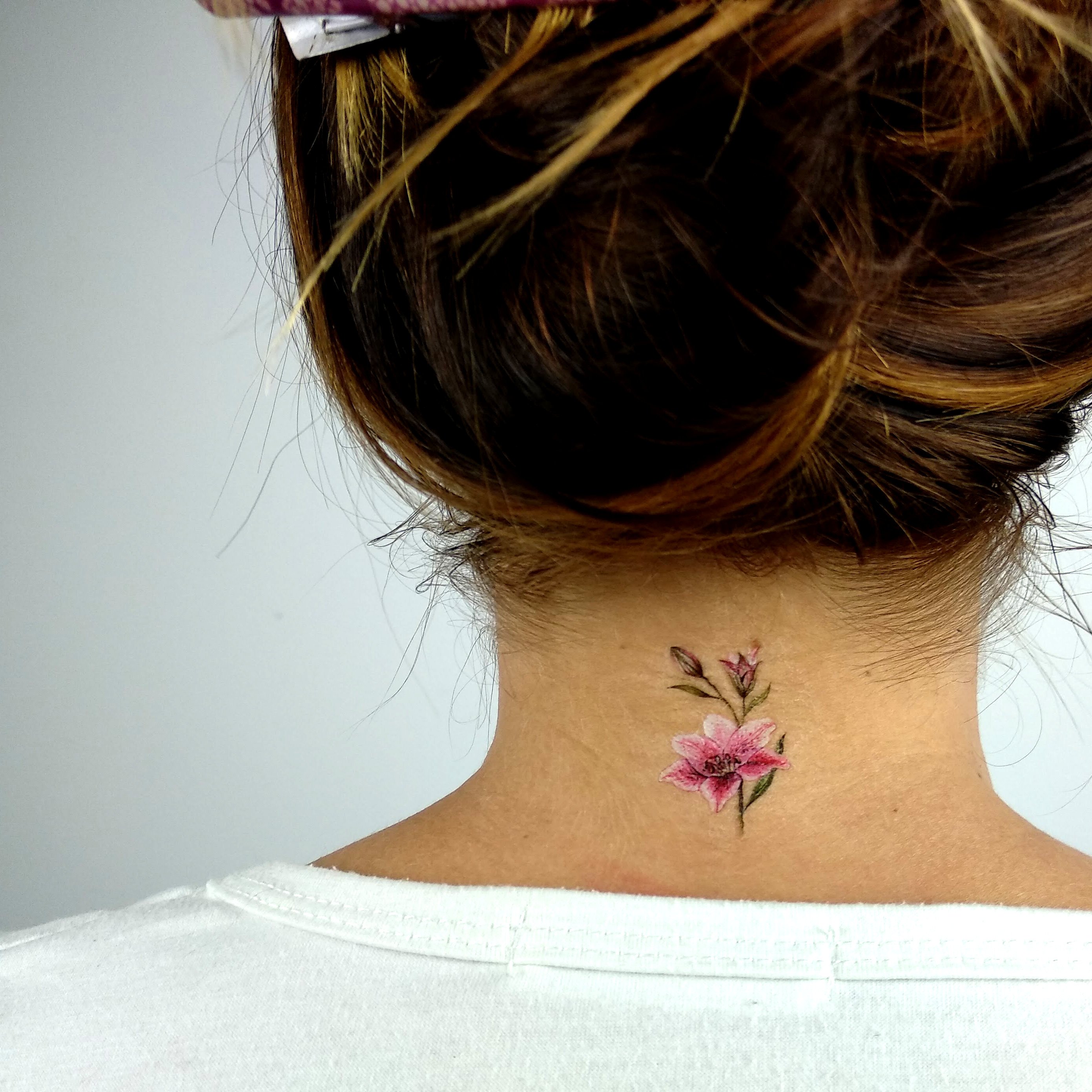 Татуировка цветок на шее у девушки