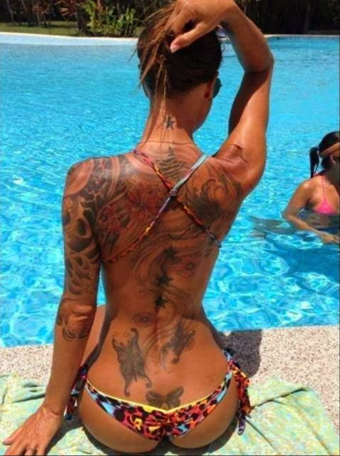 Милфа с татуировками на руках обнажает гигантские сиськи около бассейна