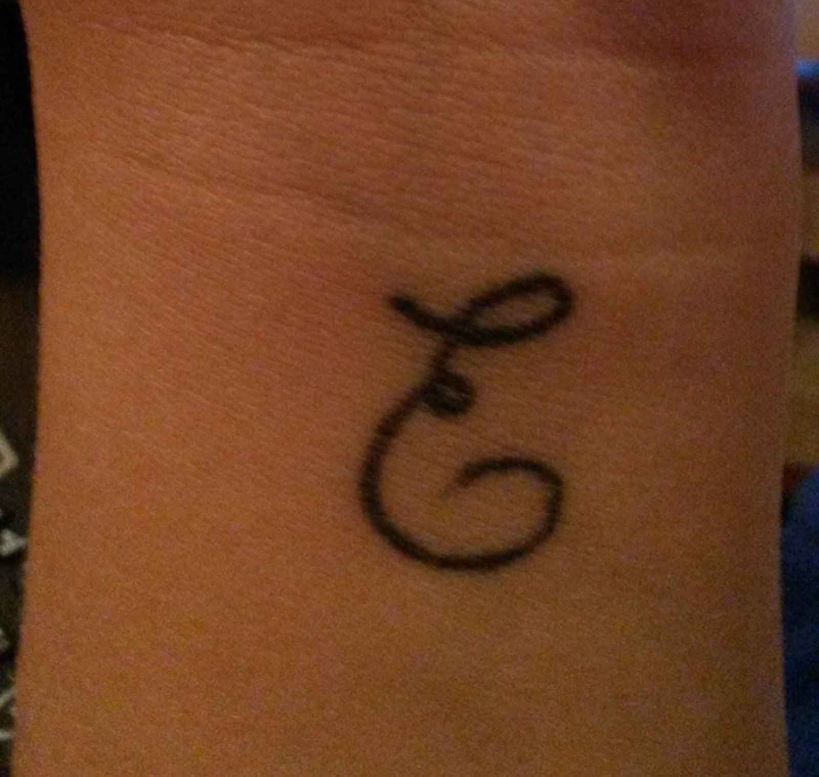 Татуировка буква е на запястье