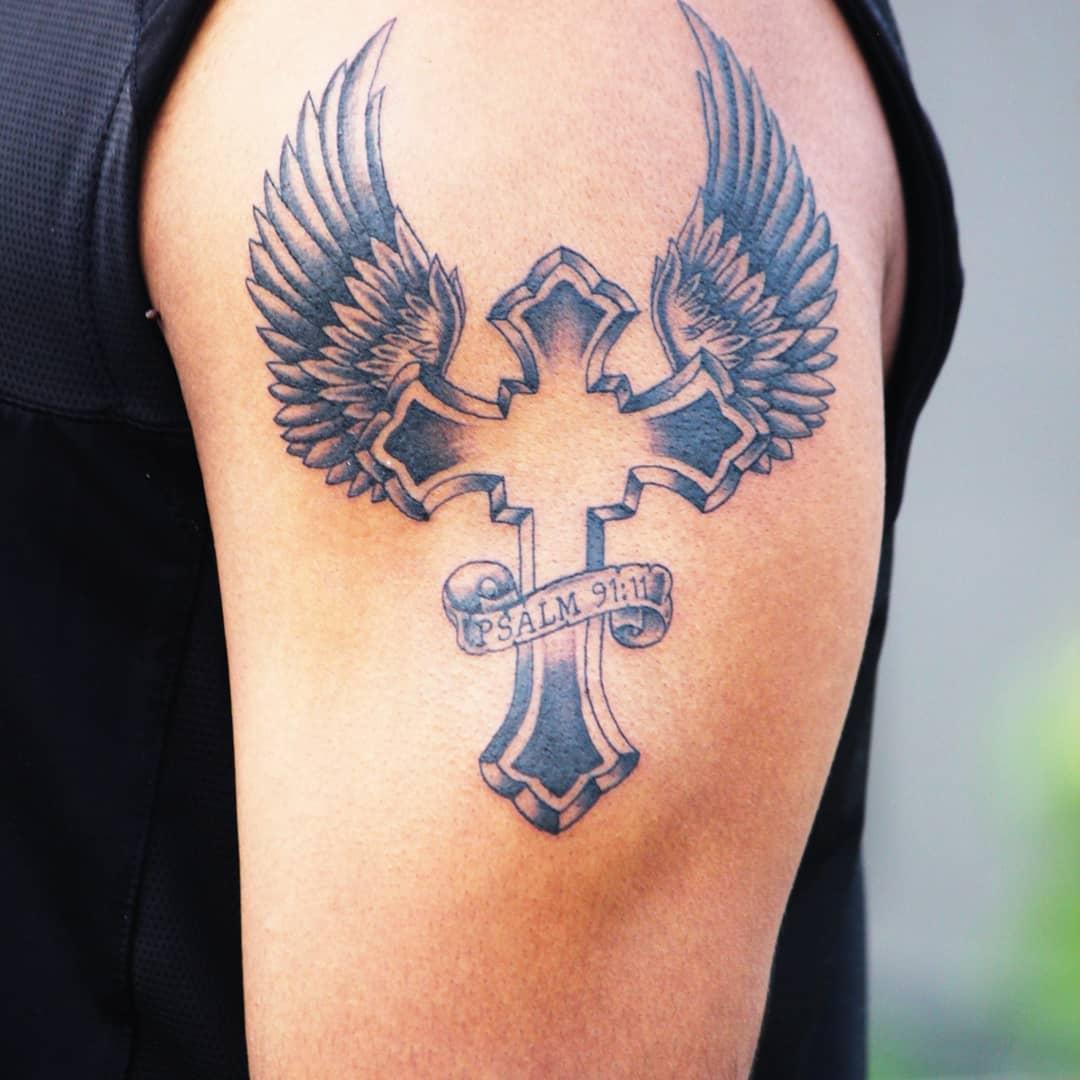 Тату крест с крыльями на руке
