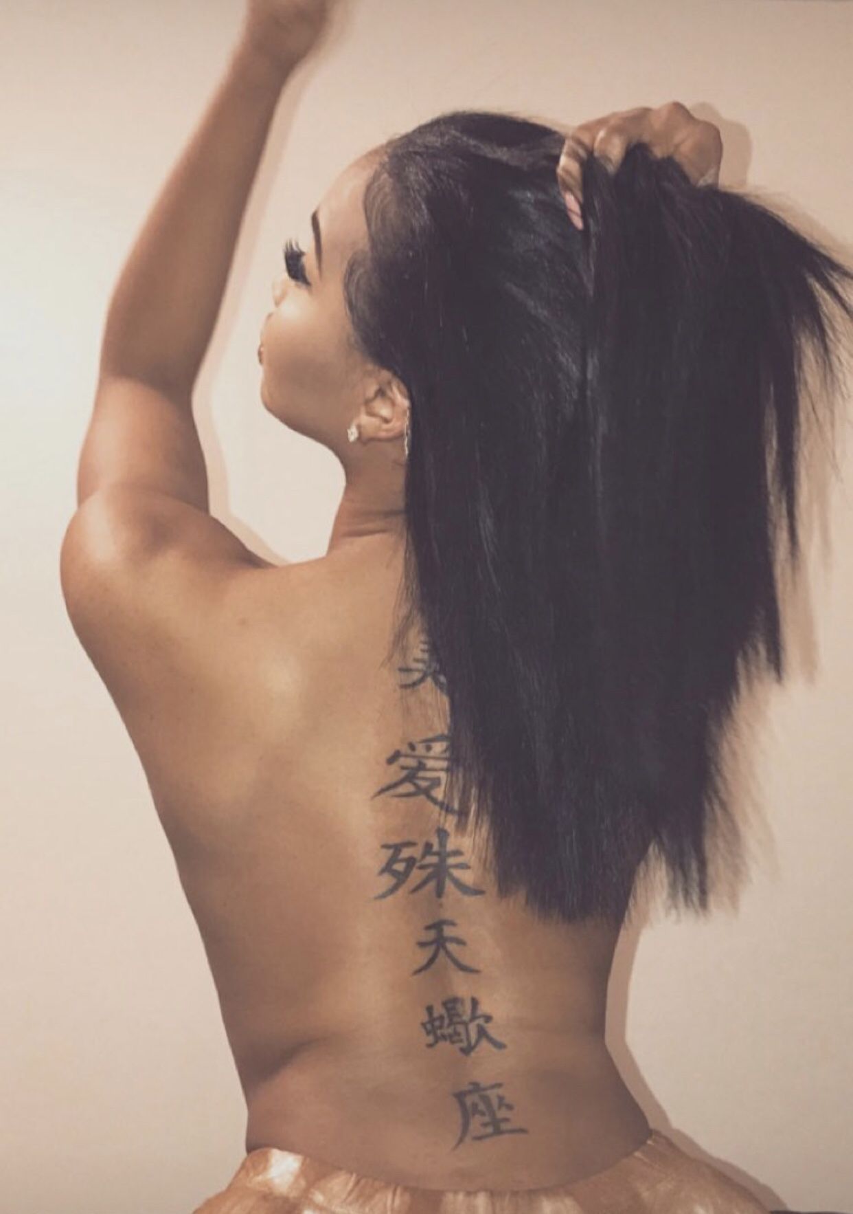 Молодая брюнетка с татуировками на теле показывает стриптиз