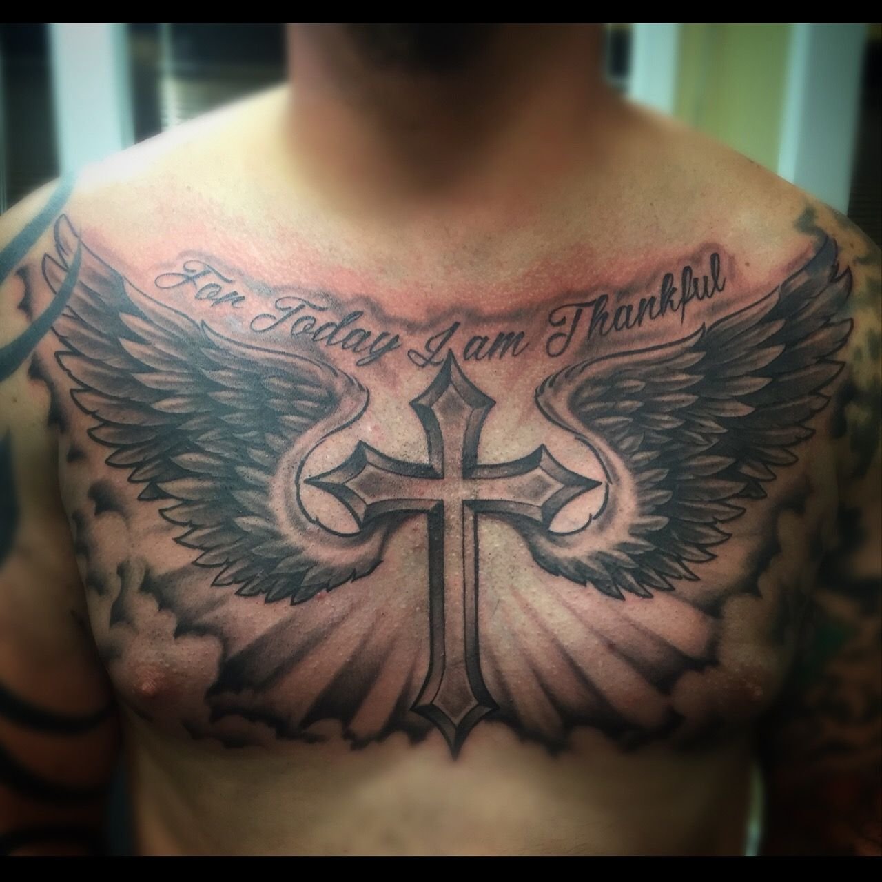 Тату крест с крыльями на груди