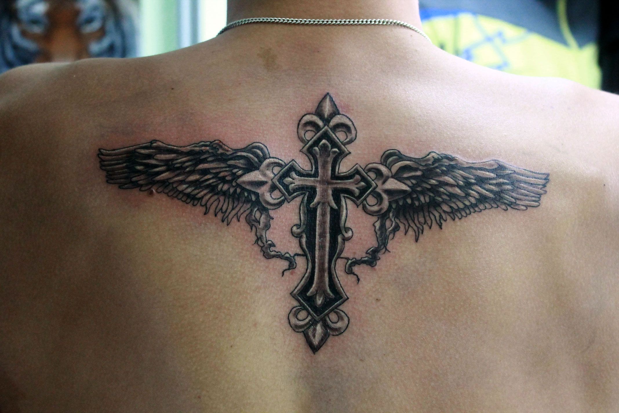 Крест с крыльями на спине